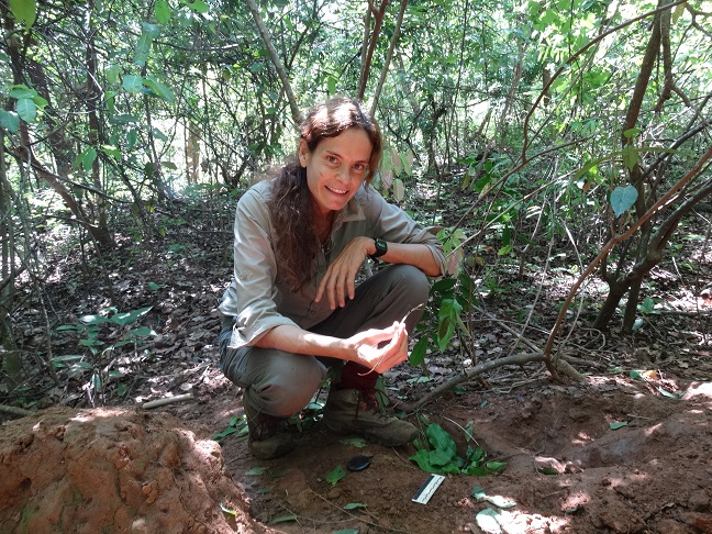 Alejandra Pascual-Garrido photographed in the forest conducting fieldwork and posing with an example of chimpanzee perishable technology