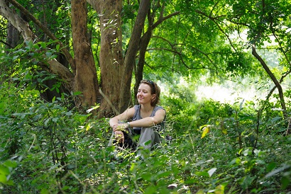 Philippa Hammond photographed sitting in the woodland of Gorongosa National Park whilst tracking baboons